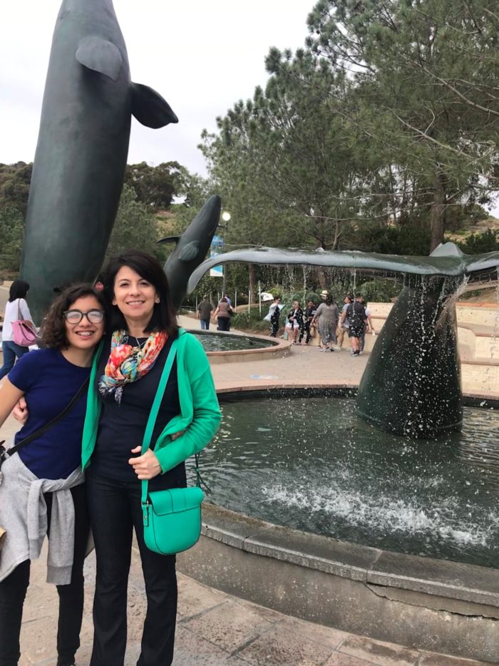 Liliana Rodriguez and her teen daughter stand in front of whale tail fountain
