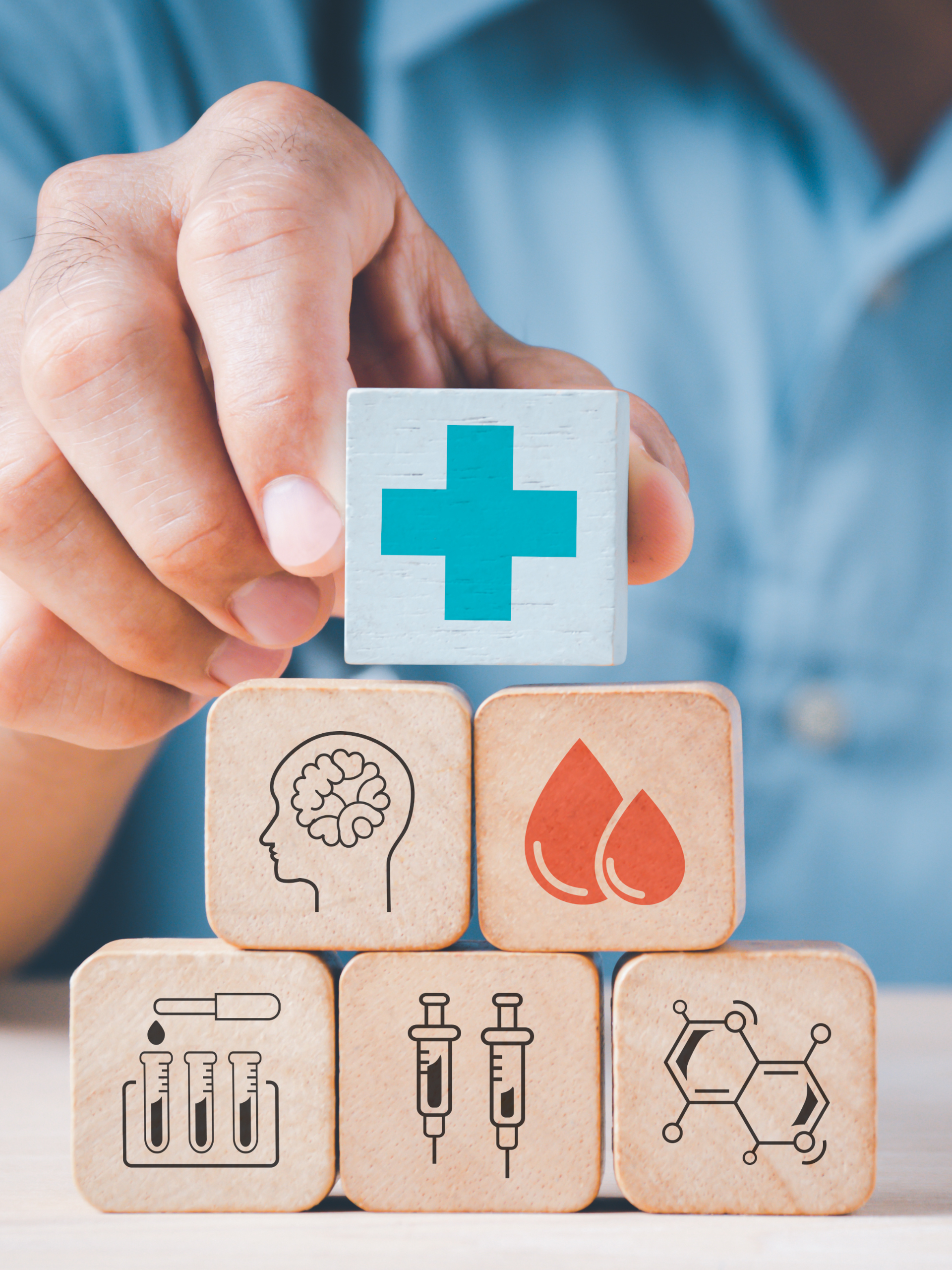 Hand stacks wooden blocks decorated with medical icons