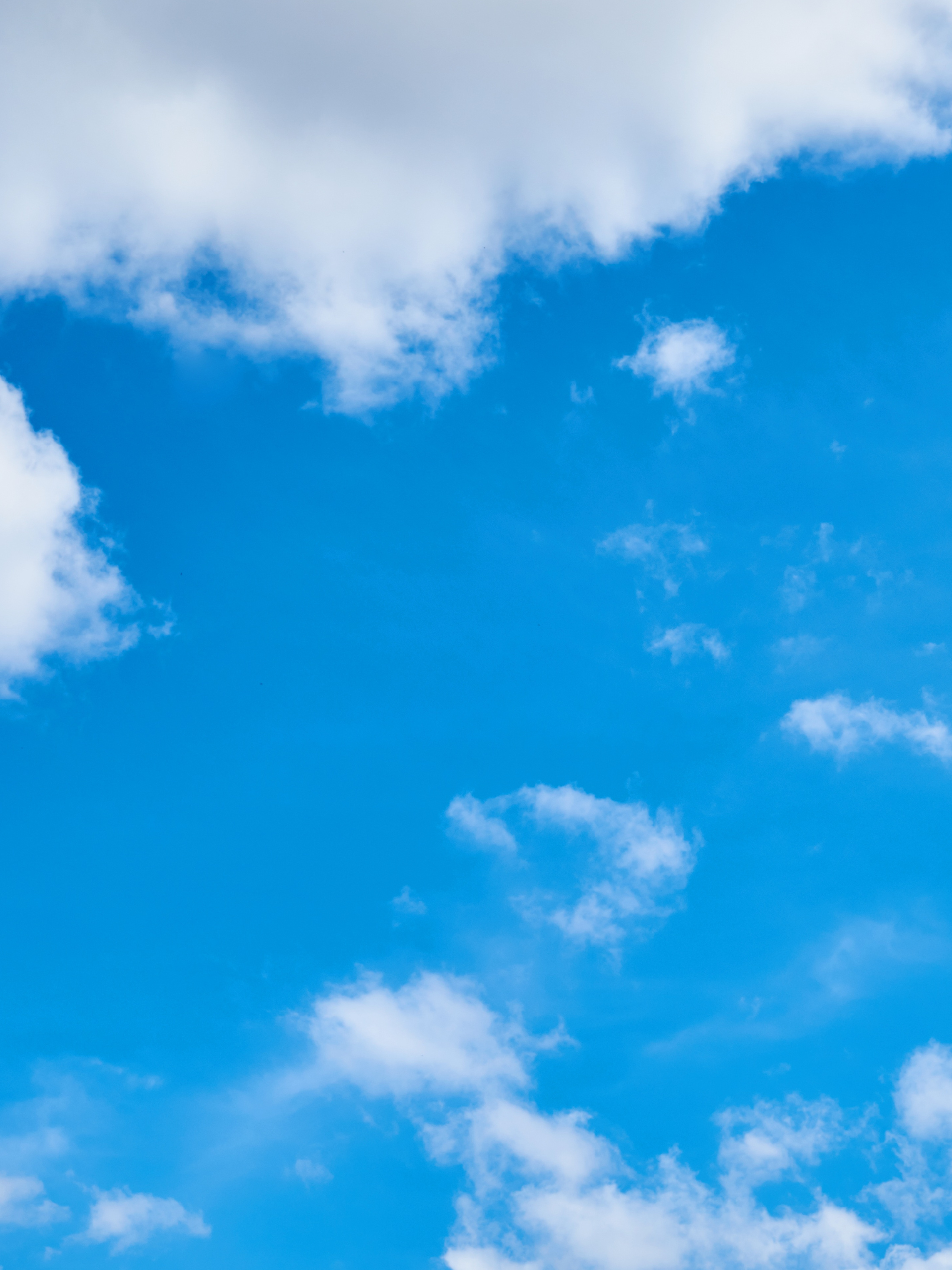 Fluffy white clouds against a blue sky