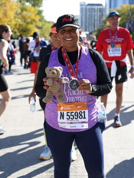 Maribel Hernandez, accounts payable finance clerk at CHOC, poses with Choco and her medal at the finish line of the Chicago marathon