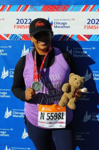 Maribel Hernandez, accounts payable finance clerk at CHOC, poses with Choco and her medal at the finish line of the Chicago marathon