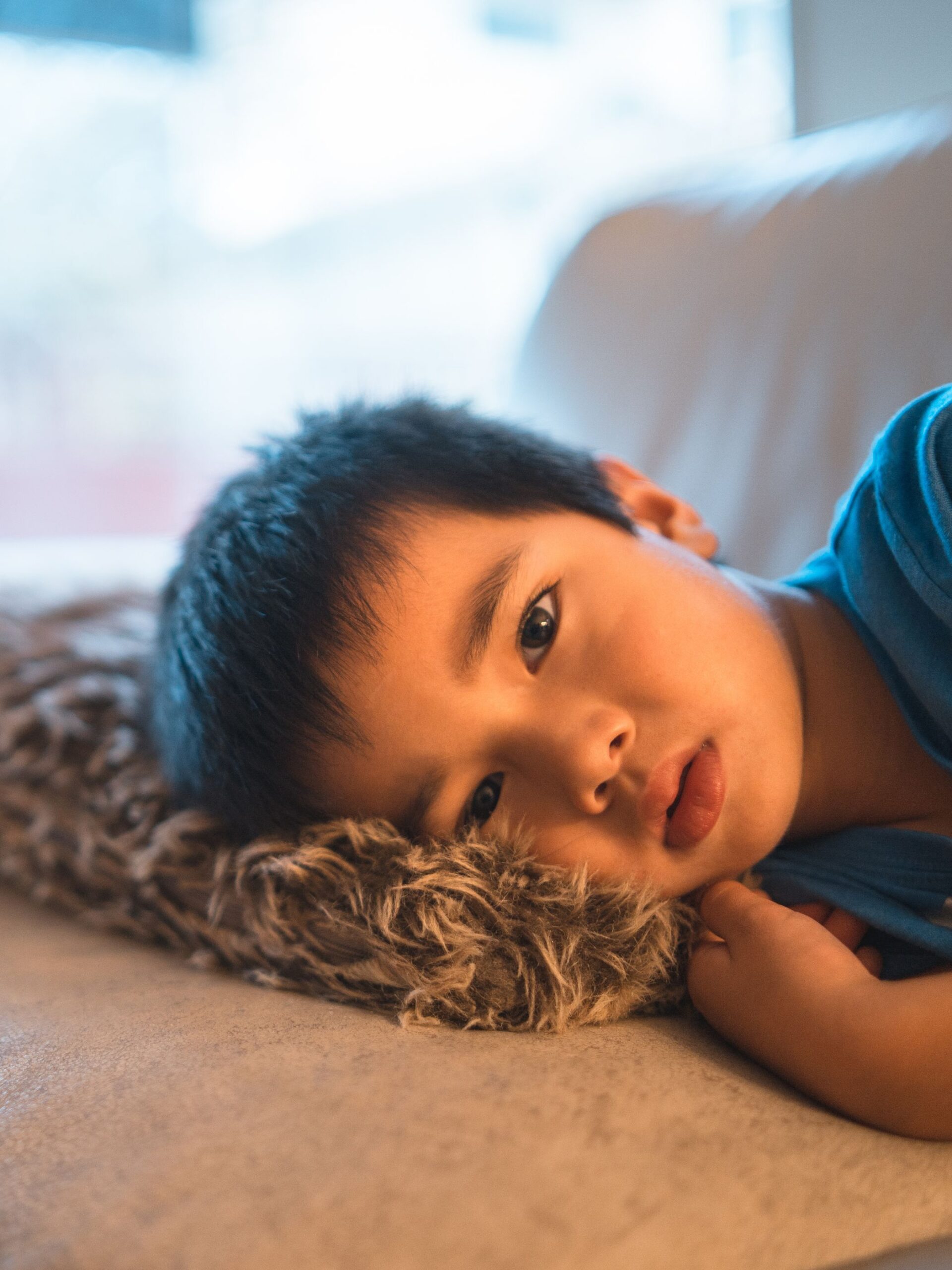 sick boy lays on soft blanket on couch