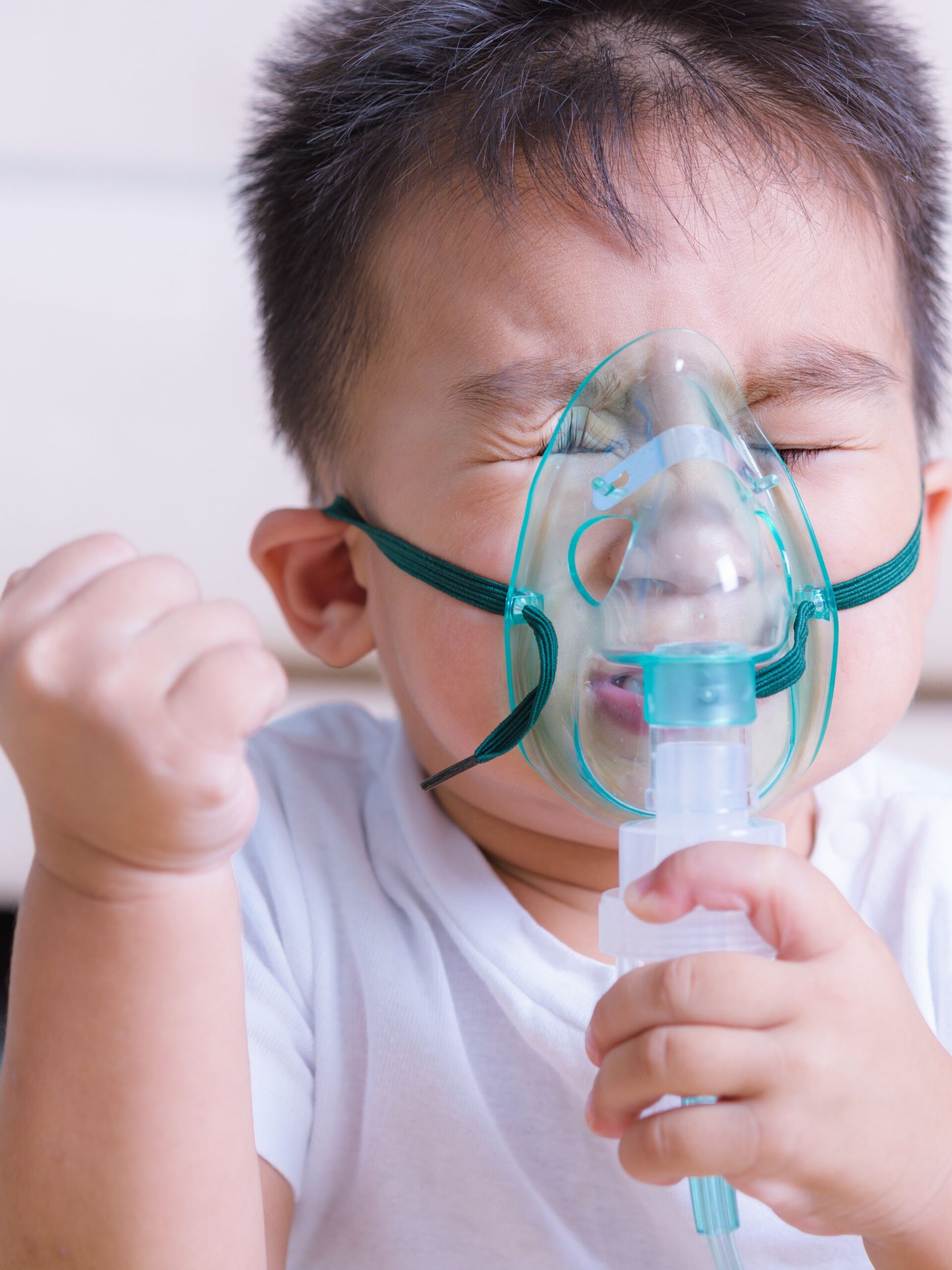 sick boy uses breathing treatment