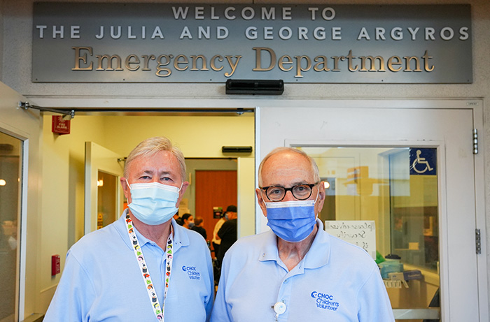 Ron Ainsworth and Jack Bruno, CHOC volunteers, standing in front of The Julia and George Argyros Emergency Department  