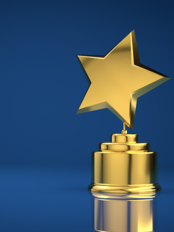 A gold trophy with a star set against a blue backdrop