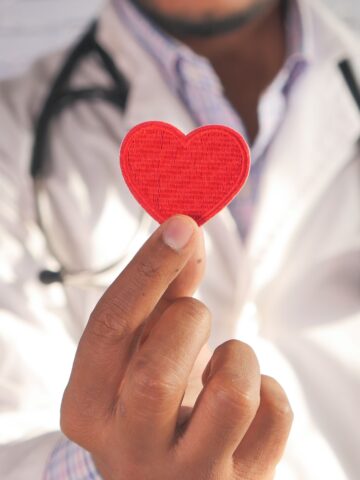 Medical provider holding a red fabric heart