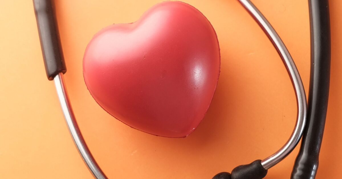 A stethoscope is positioned around a model heart