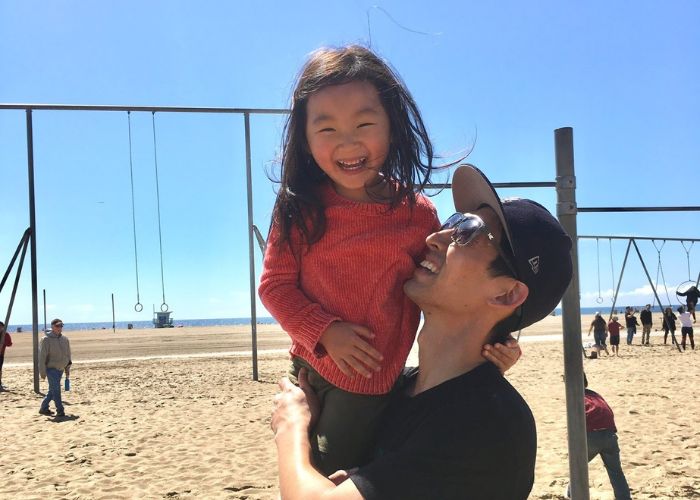 Father holds daughter at beach