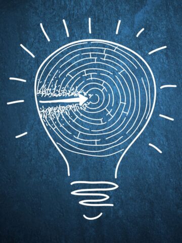 A drawing of a lightbulb with a maze inside set against a blue background