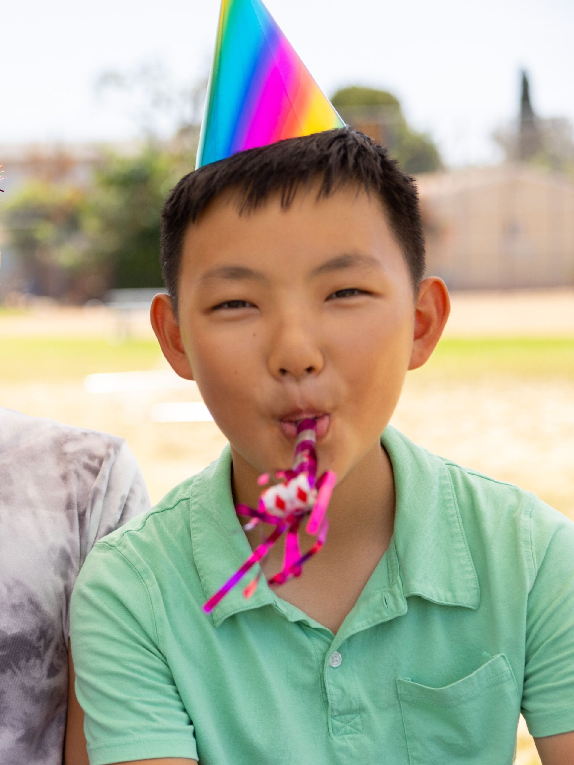 Boy with dark hair wearing party hat and blowing party blower - CHOC earns national honor for digital excellence