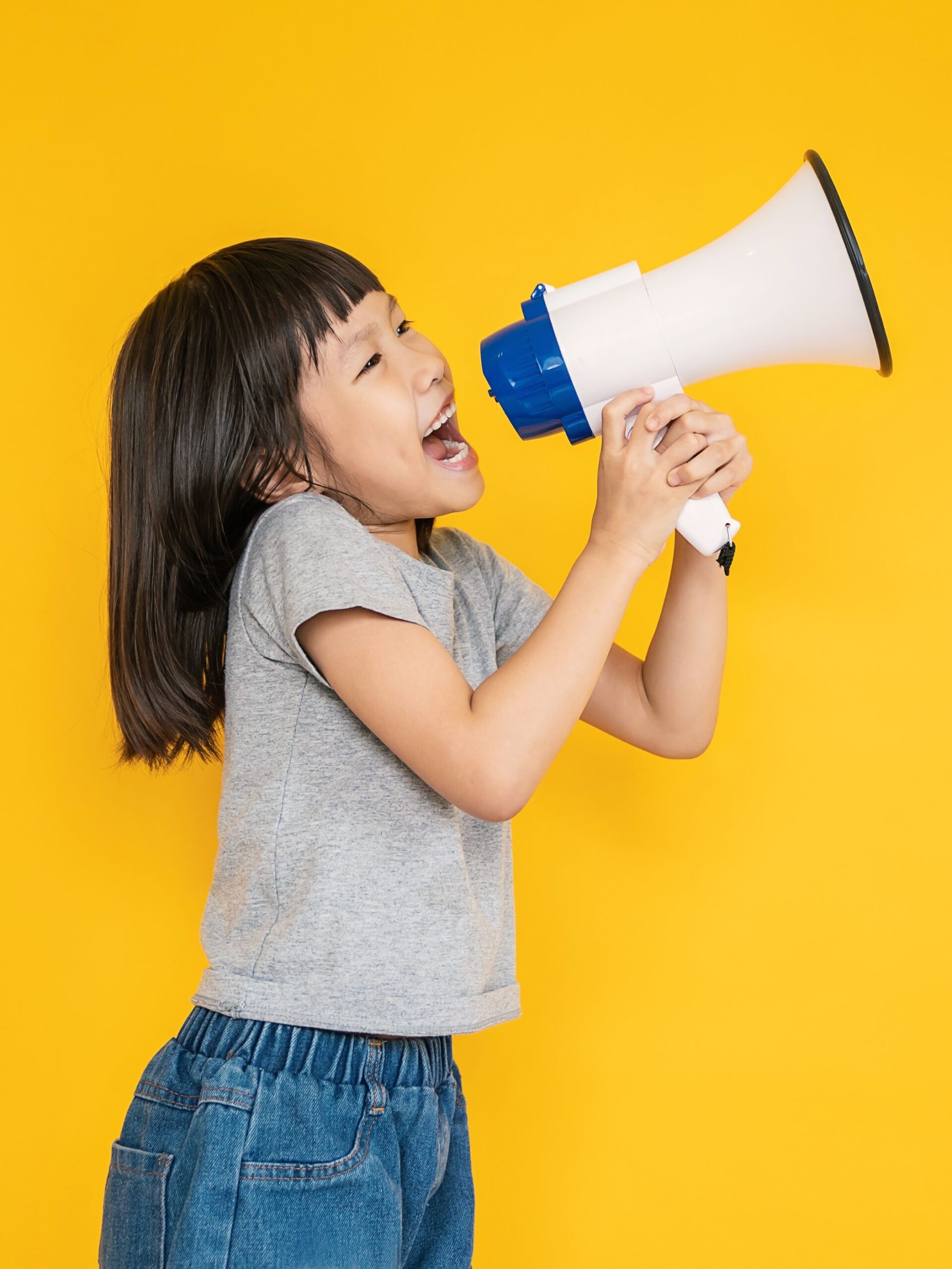 Young girl with black hair speaking into megaphone