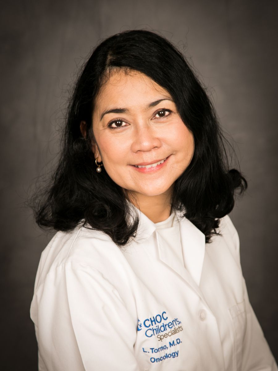 Headshot - Dr. Lilibeth Torno - Woman in while lab coat looks into the camera and smiles