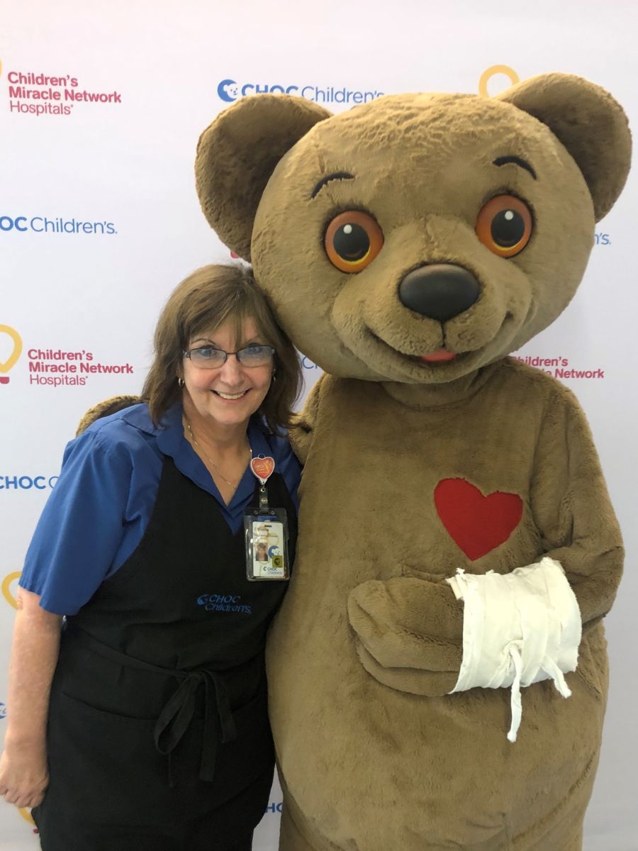 Christine McGuigan, food service worker II at CHOC, with Choco mascot - CHOC defender profile