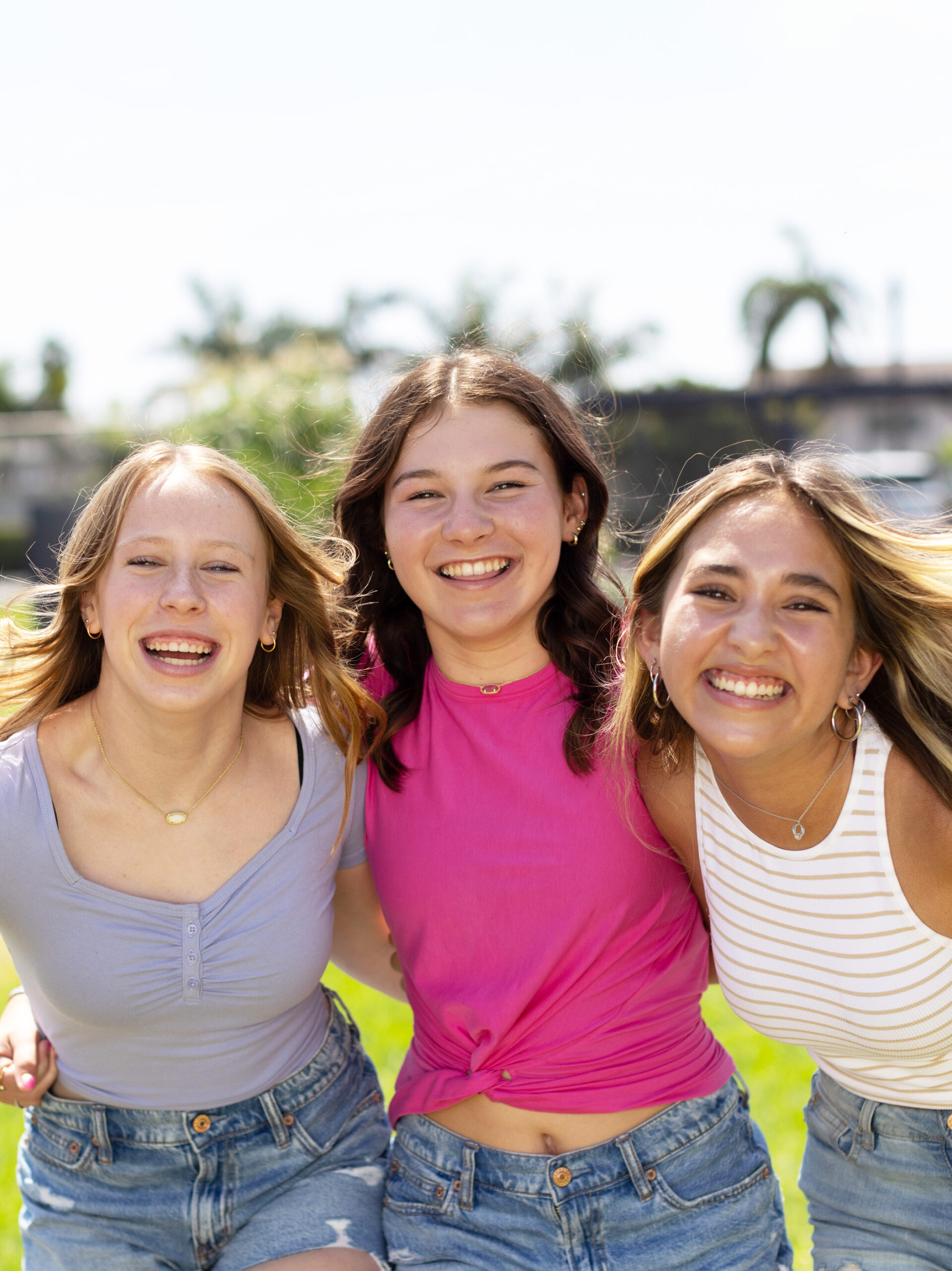 Three teenagers look at the camera and smile together