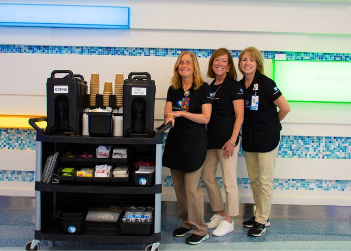 Sue, Paula and Kris (from left to right) pose with the coffee cart they bring throughout the hospital.