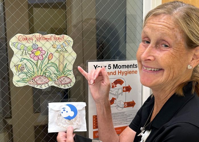 Sue shows a sign on a patient room that made her and her friends' days.