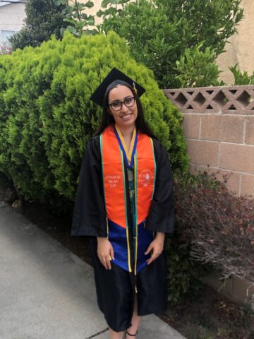 Woman in black graduation gown and cap